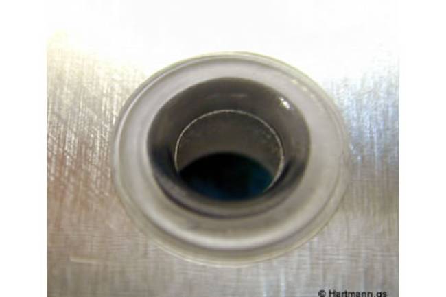 Ein Blech-Stanzteil wird durch einen heißverstemmten Pin in seiner Position fixiert.